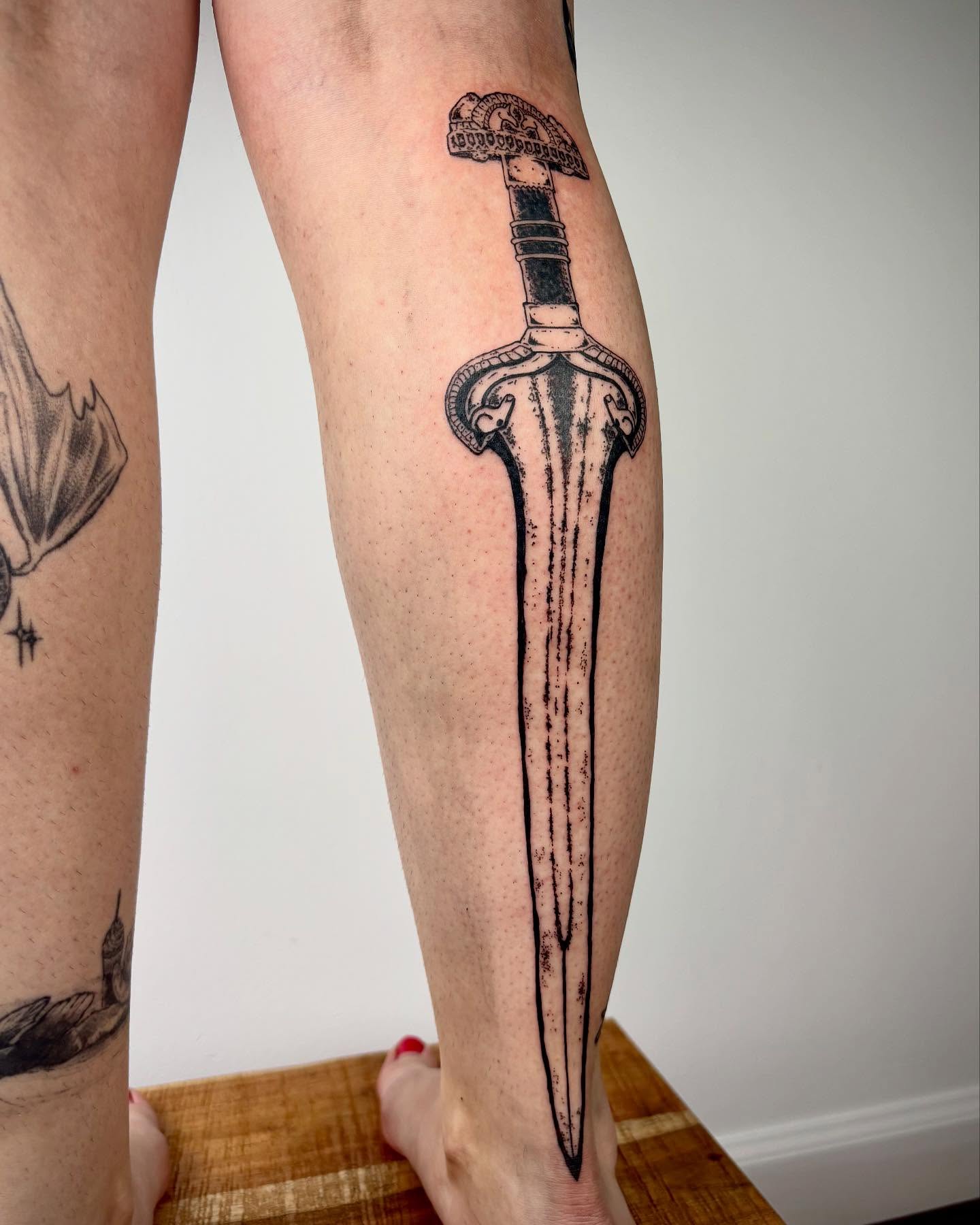 Sword black and grey tattoo on the calf by kendle