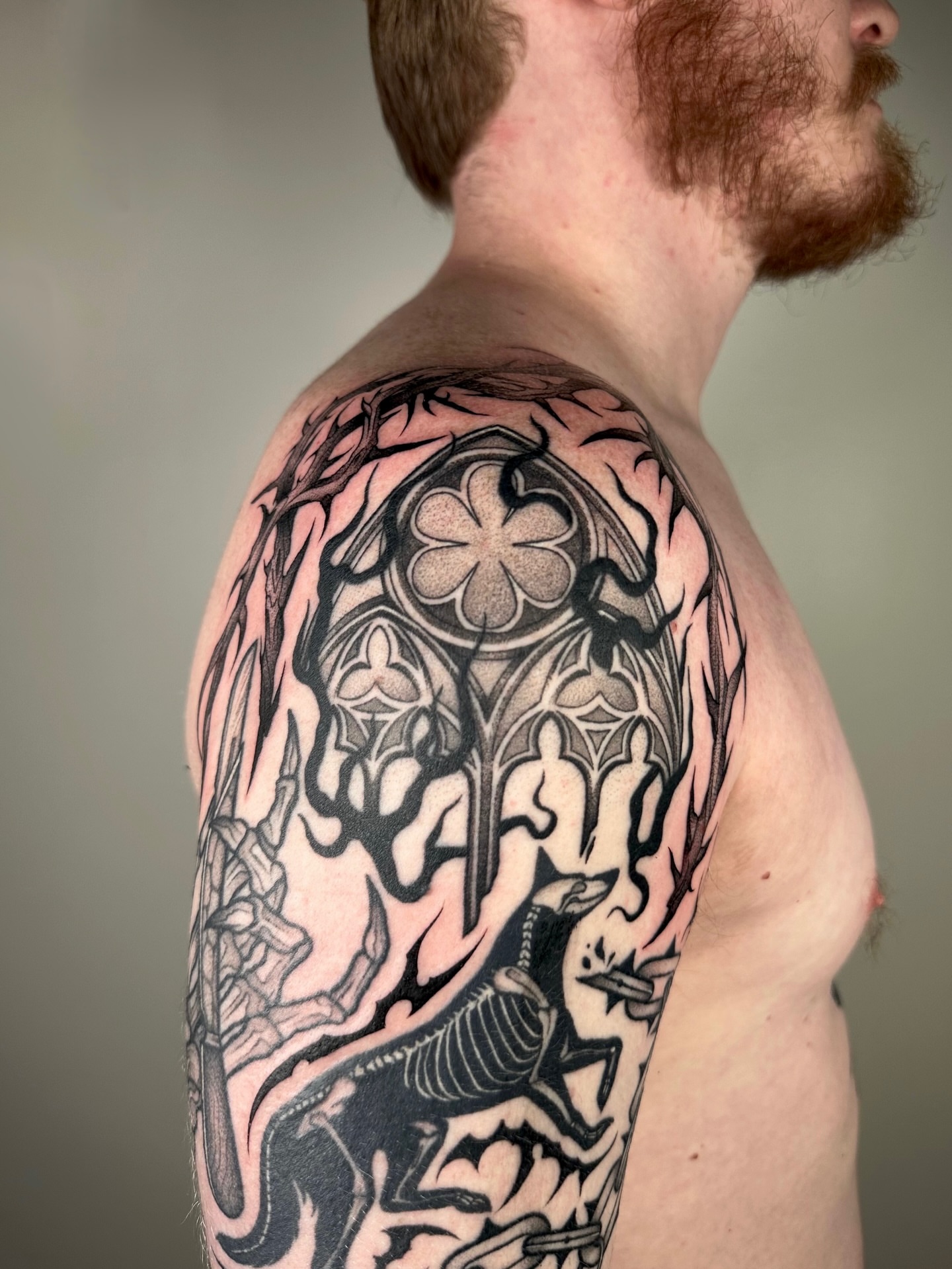 Gothic arches and creatures geometric tattoo on the shoulder by Brooklyn Bailey