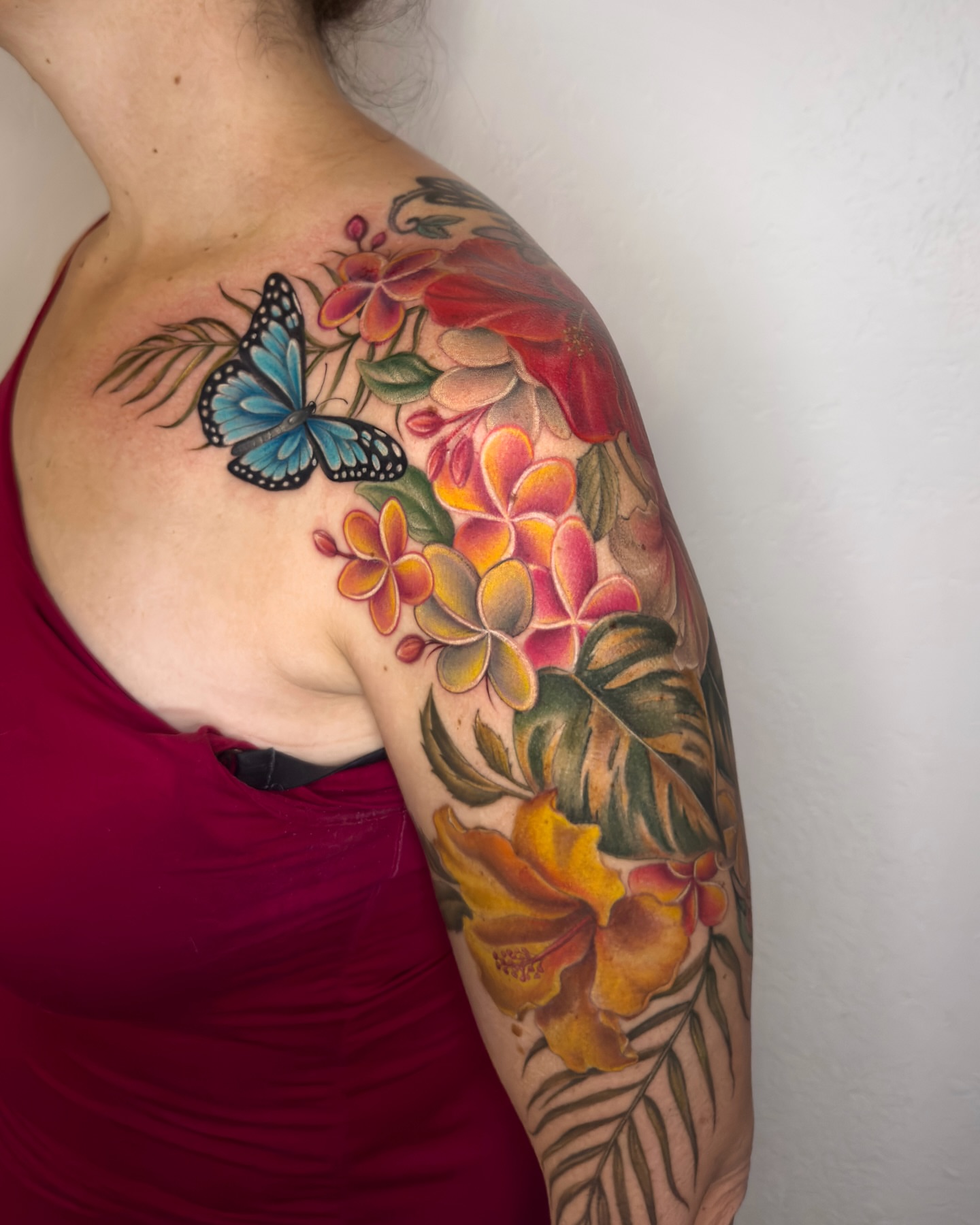 Butterfly and flowers realism tattoo on the shoulder by Nichole Lorence