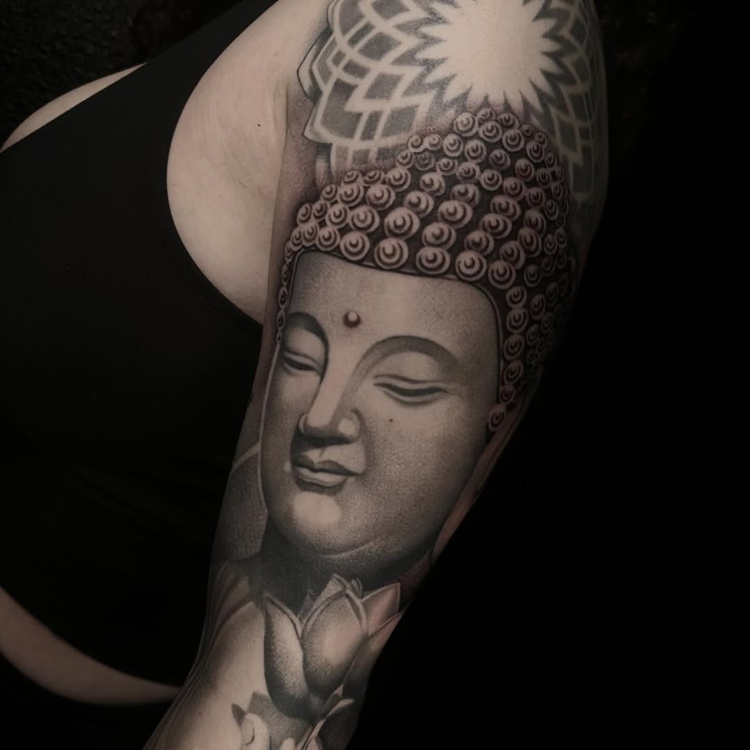 Buddha face with lotus realism tattoo on the forearm by DH Tattooing