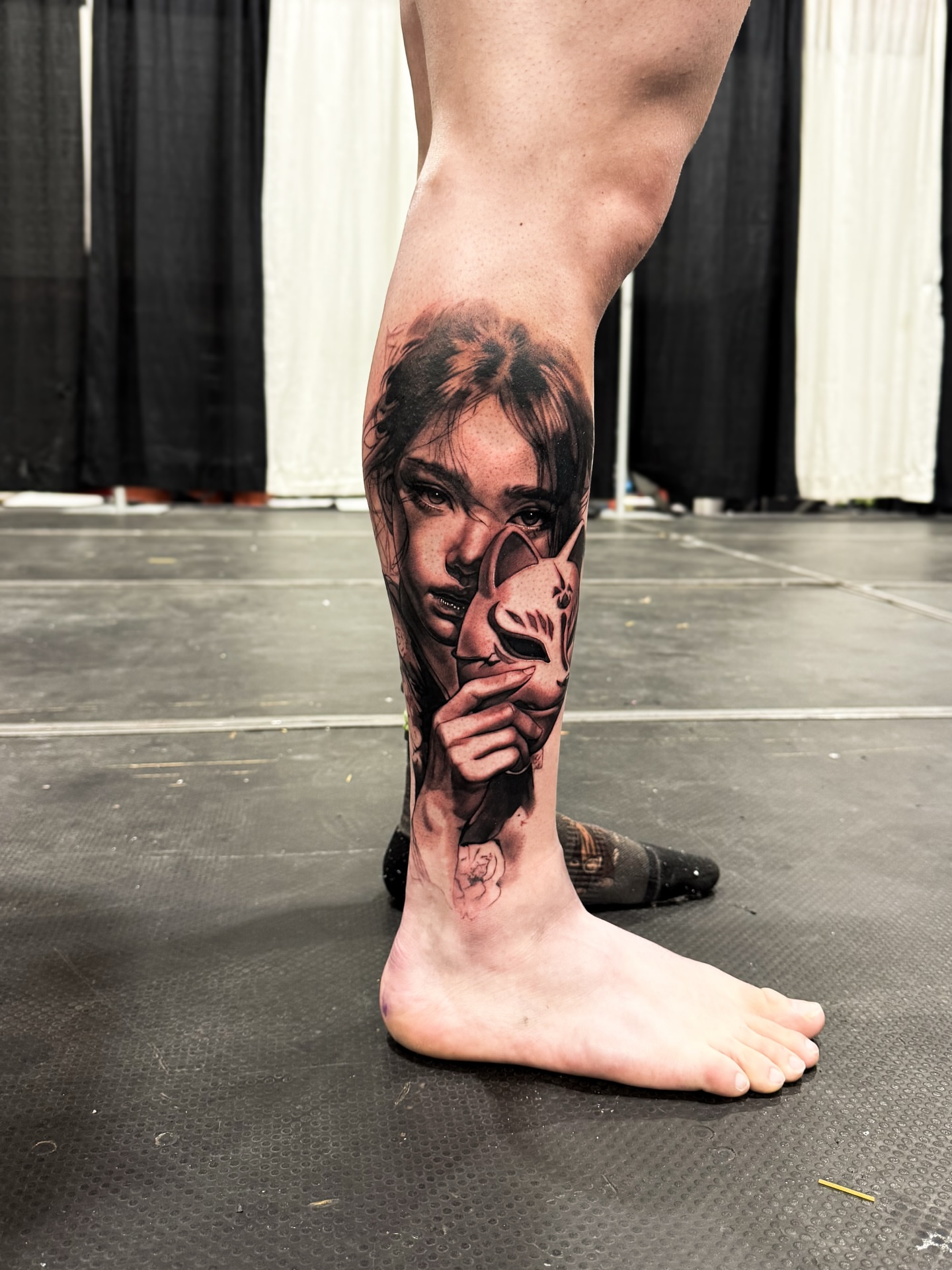 Woman with mask realism tattoo on the calf by Anastasia Ritova