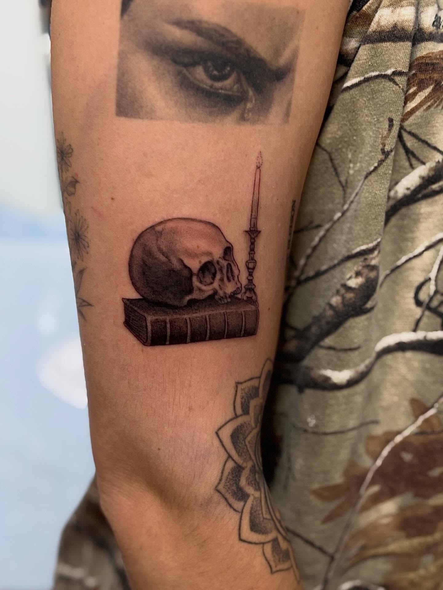 Skull and book realism tattoo on the forearm by Dylan Coverdale