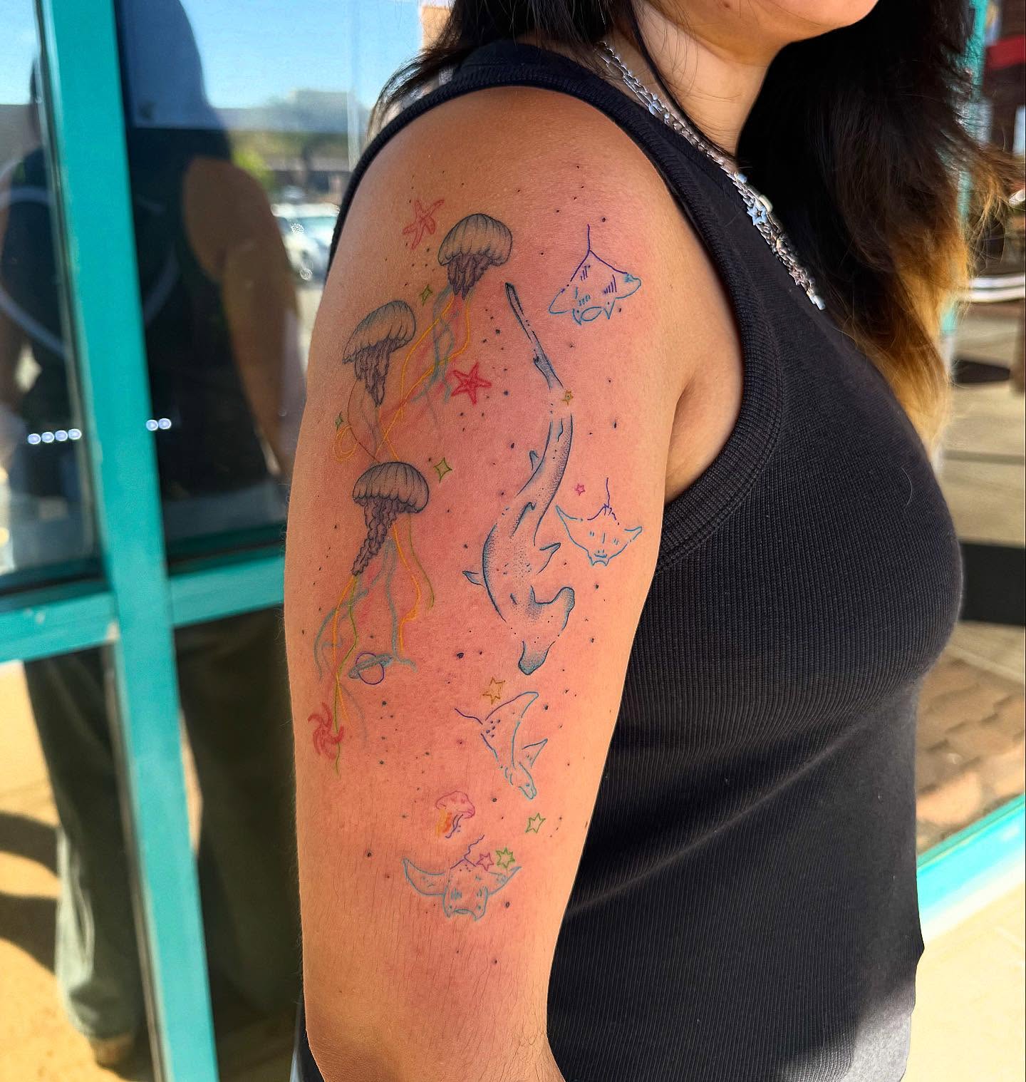 Jellyfish and stingrays dotwork tattoo on the upper arm by McKenna Hughes