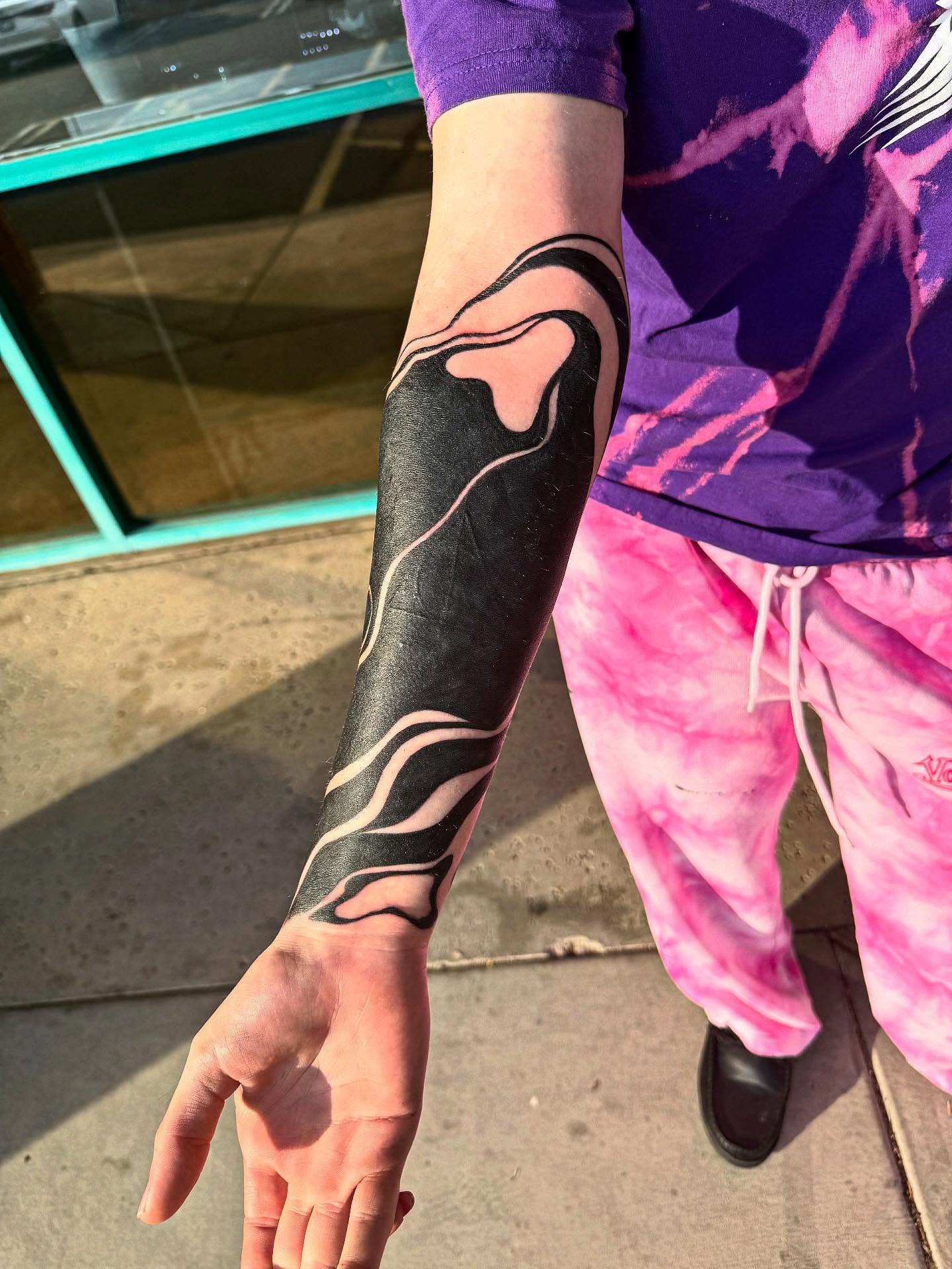 Abstract flame black and grey tattoo on the forearm by McKenna Hughes