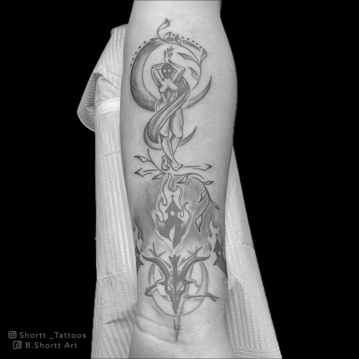 Goat head and cross black and grey tattoo on the forearm by Brie Marie