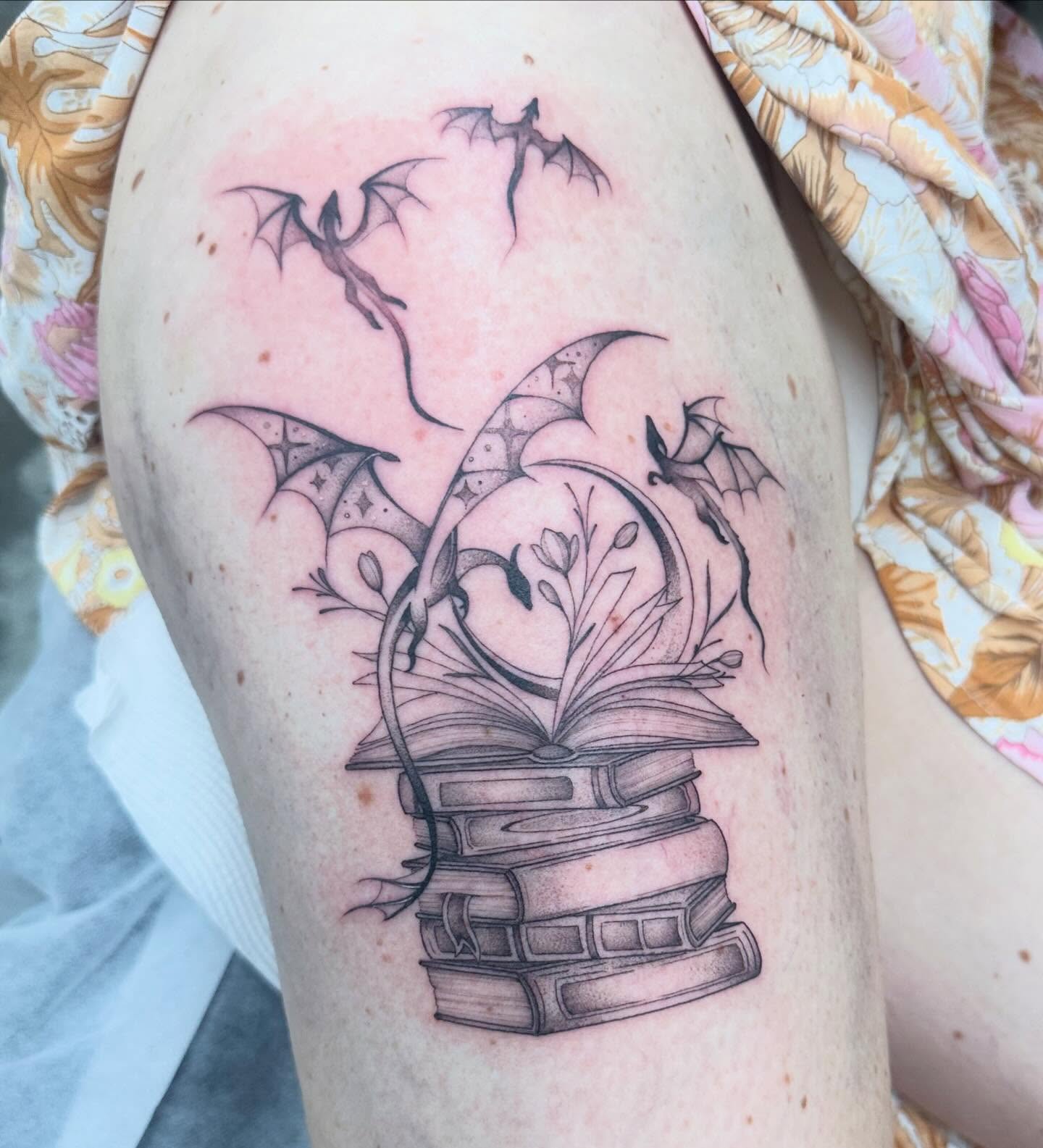 Book and dragon realism tattoo on the thigh by Lyndsay Southgate