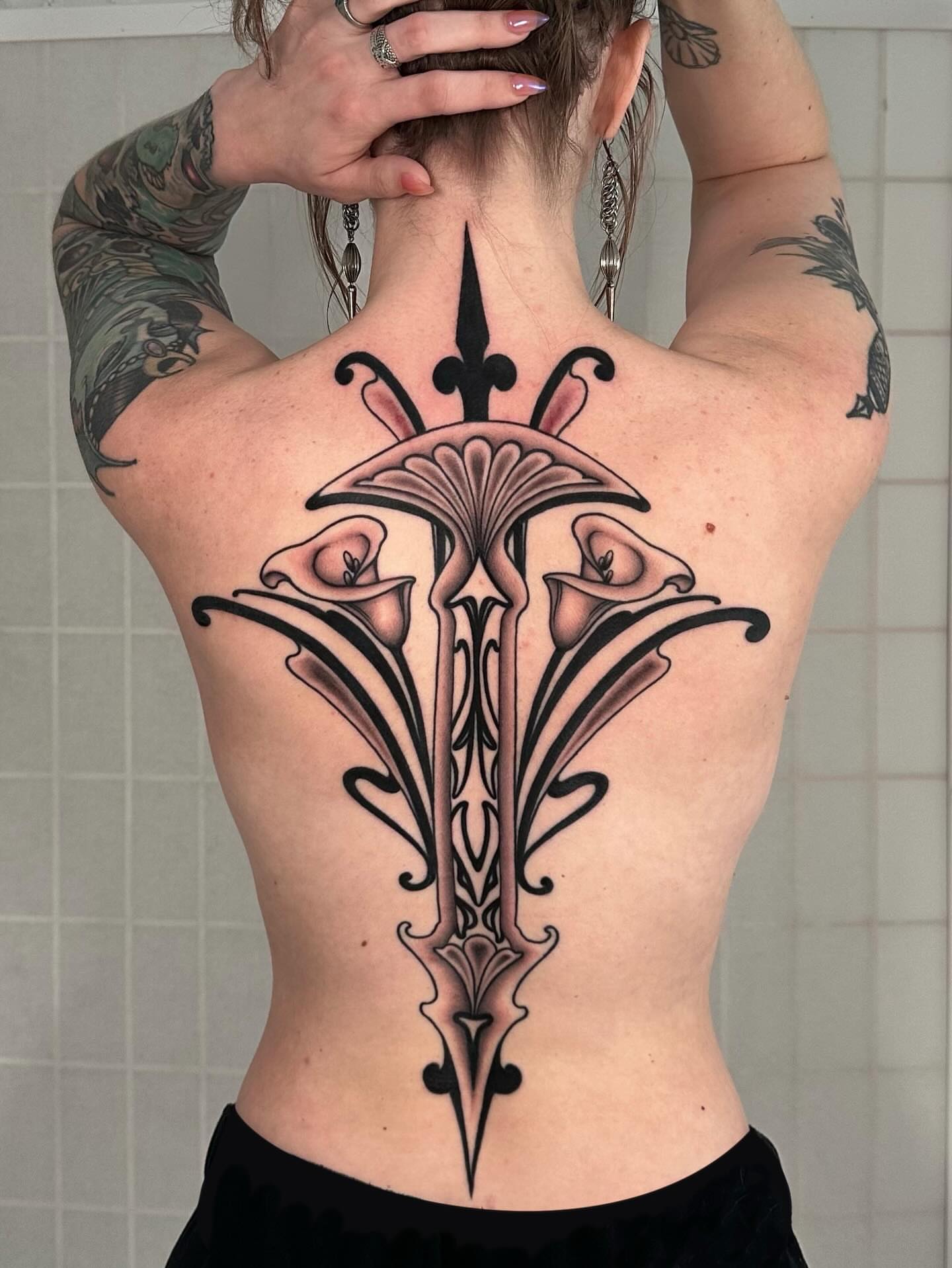 Calla lilies geometric tattoo on the back by Henry Gaßner