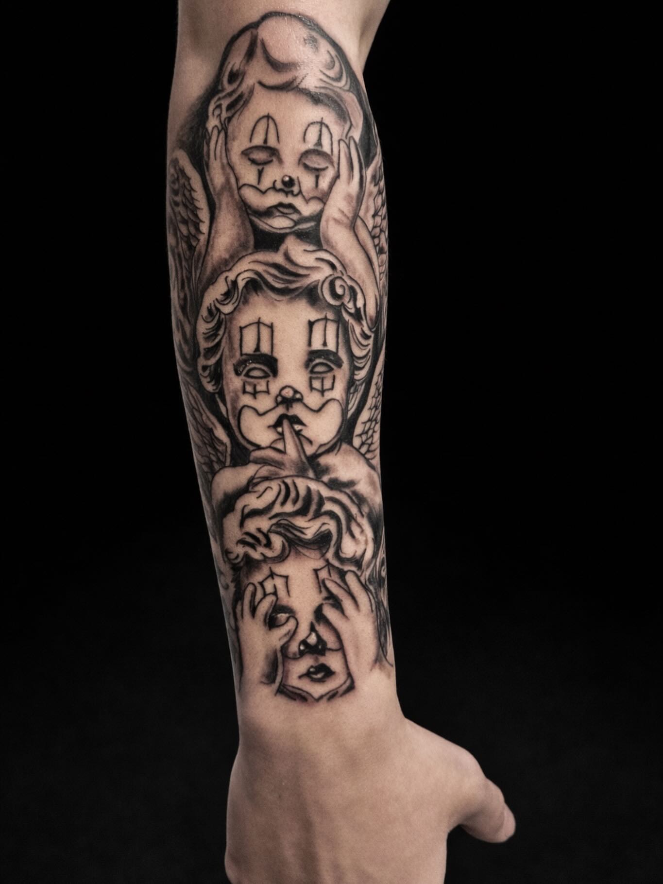 Clown faces black and grey tattoo on the forearm by Salvador Mendoza, Sesto San Giovanni