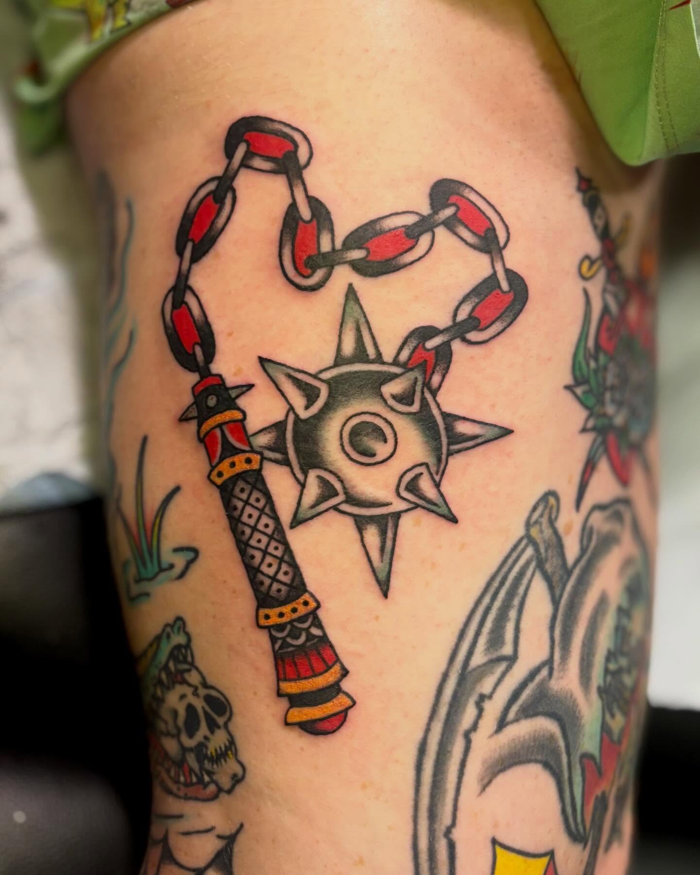 Chain and spiked weapon American traditional tattoo on the thigh by Tia Cave
