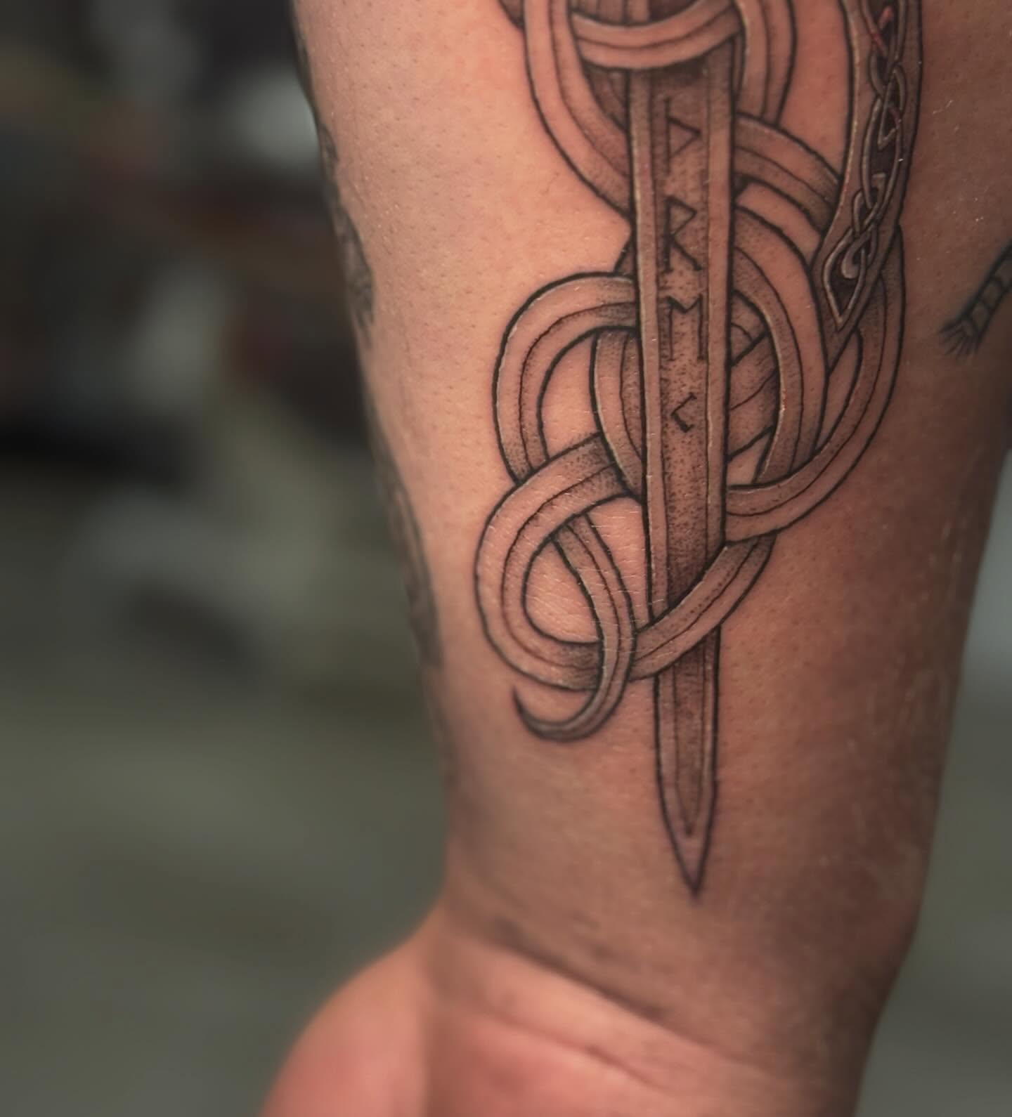 Sword and knotwork black and grey tattoo on the forearm by goose 🪿
