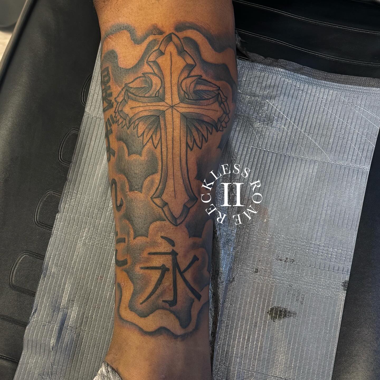 Cross with clouds black and grey tattoo on the forearm by Rome