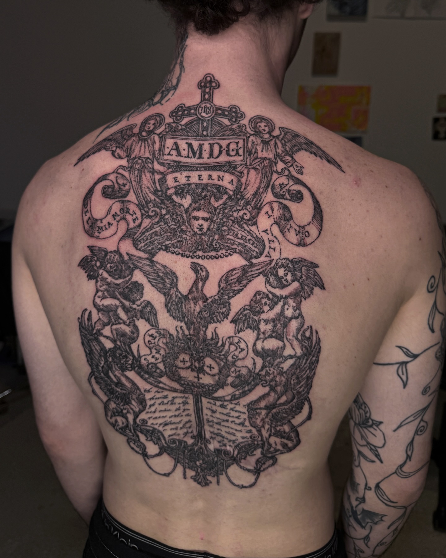 Religious emblem black and grey tattoo on the back by Penelope