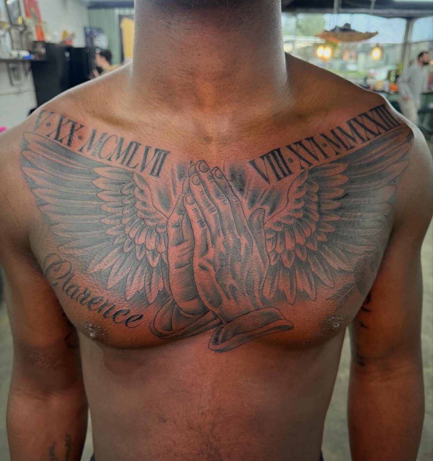 Praying hands with wings black and grey tattoo on the chest by Jake Horstman, Dayton, Ohio