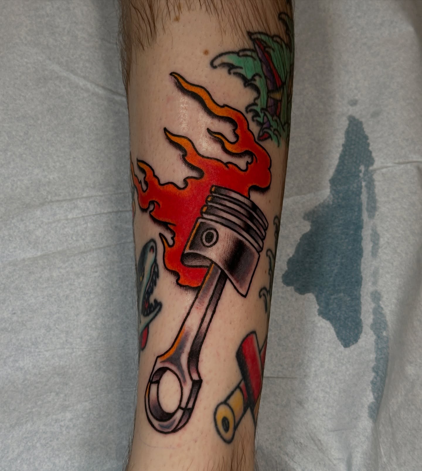 Piston and flame American traditional tattoo on the forearm by Jared, Addison, Texas