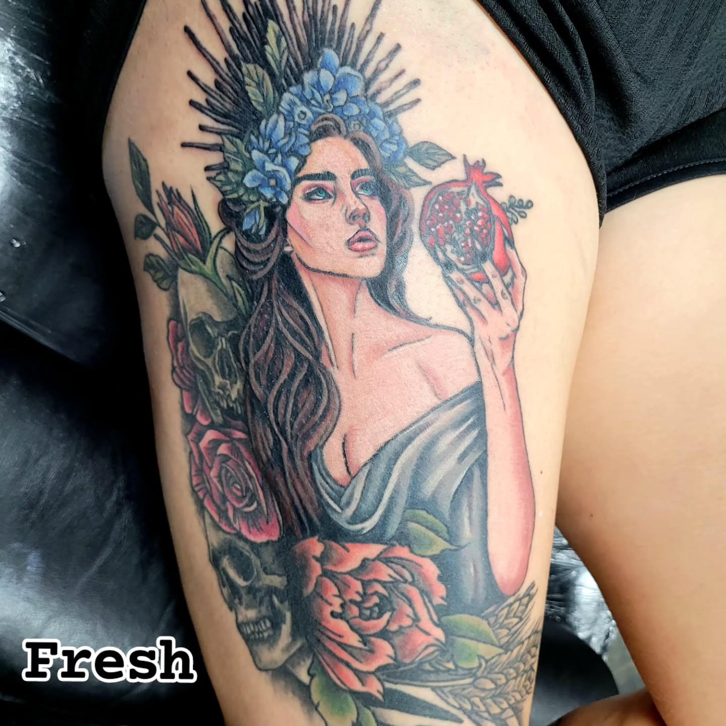 Woman with flowers and pomegranate realism tattoo on the thigh by Jentrey McCausland