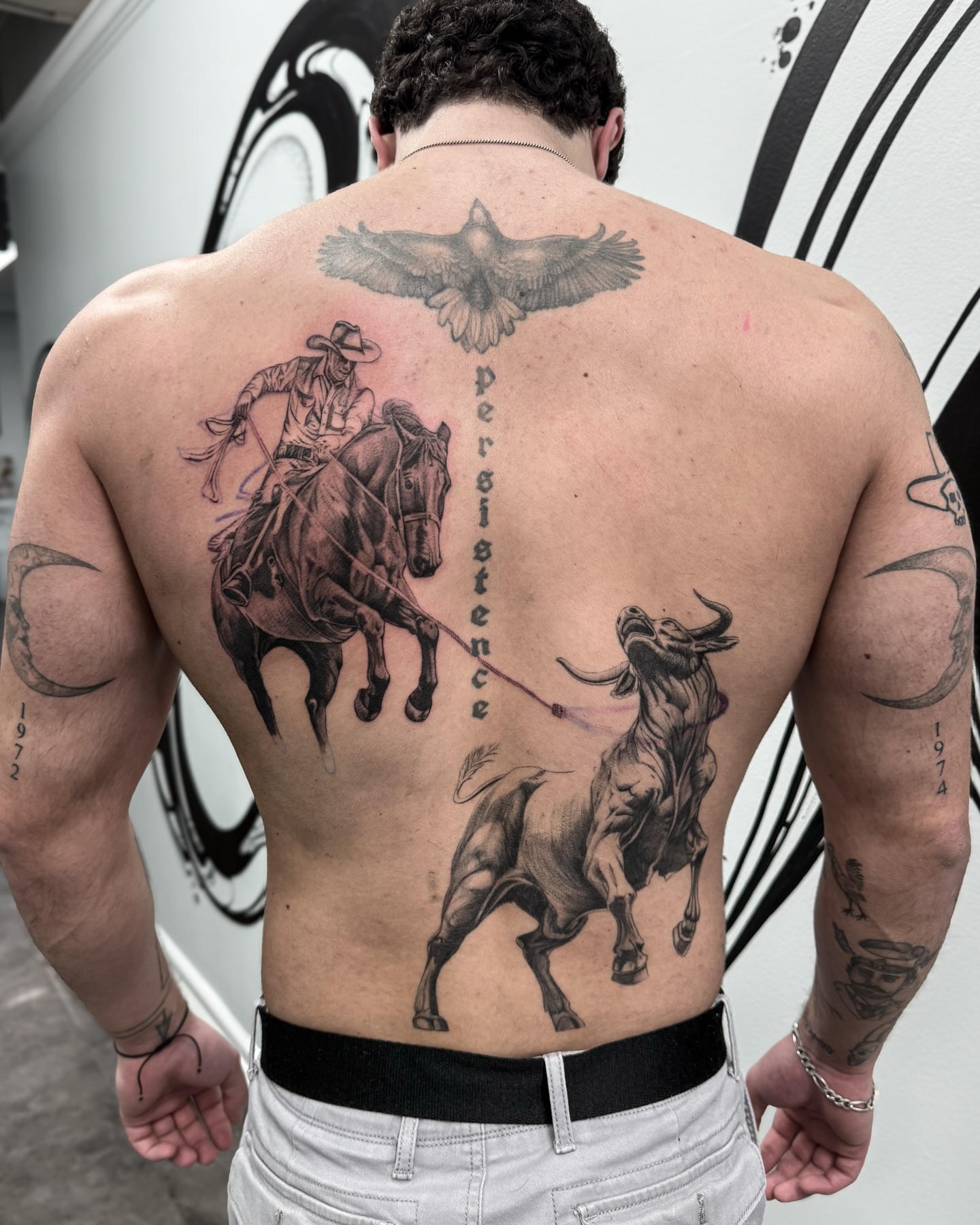 Cowboy chasing bull realism tattoo on the back by Brows & Tattoos
