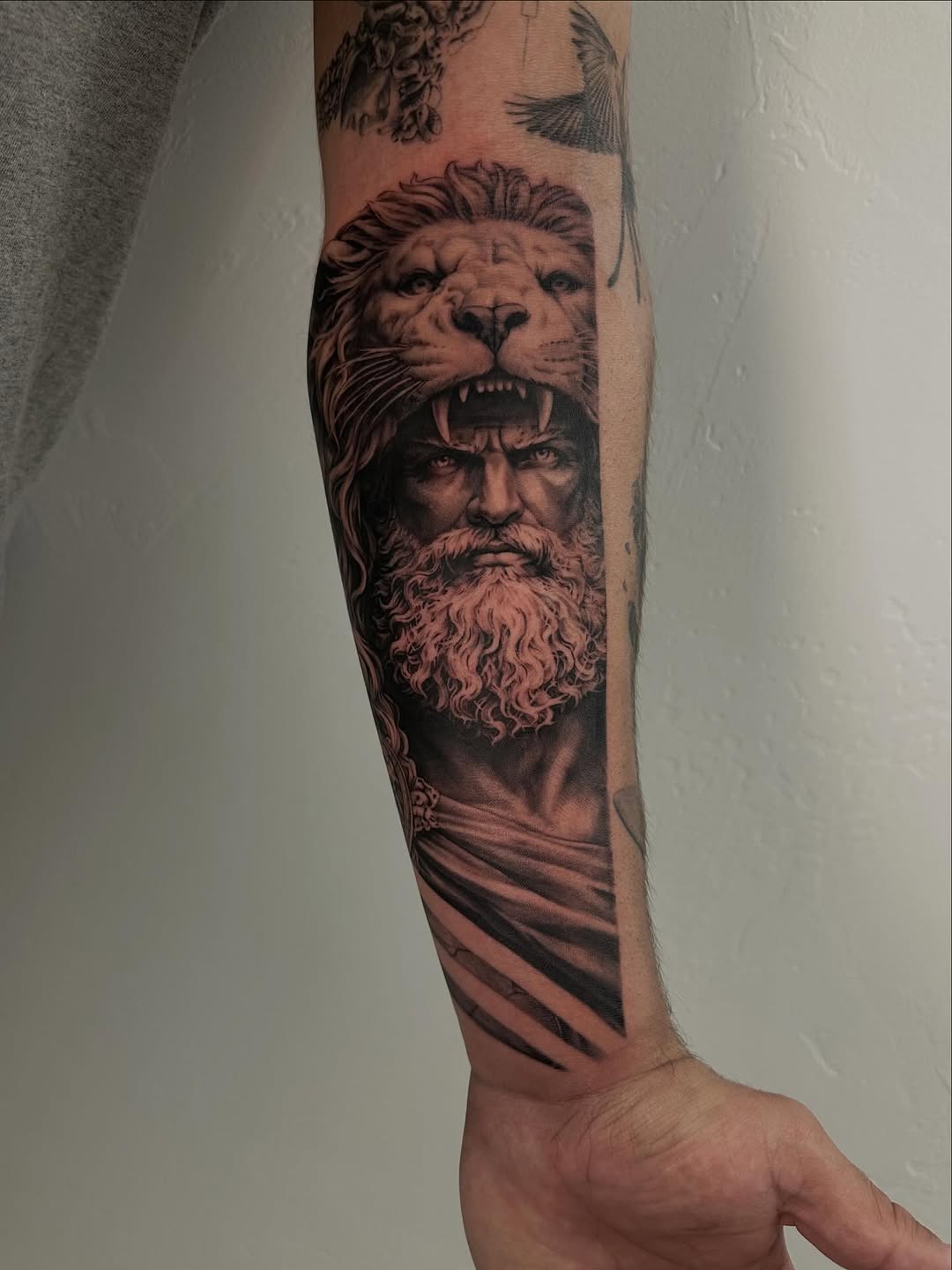 Man wearing a lion's head surrealism tattoo on the forearm by Winters Ashurst - St. George tattoo artist