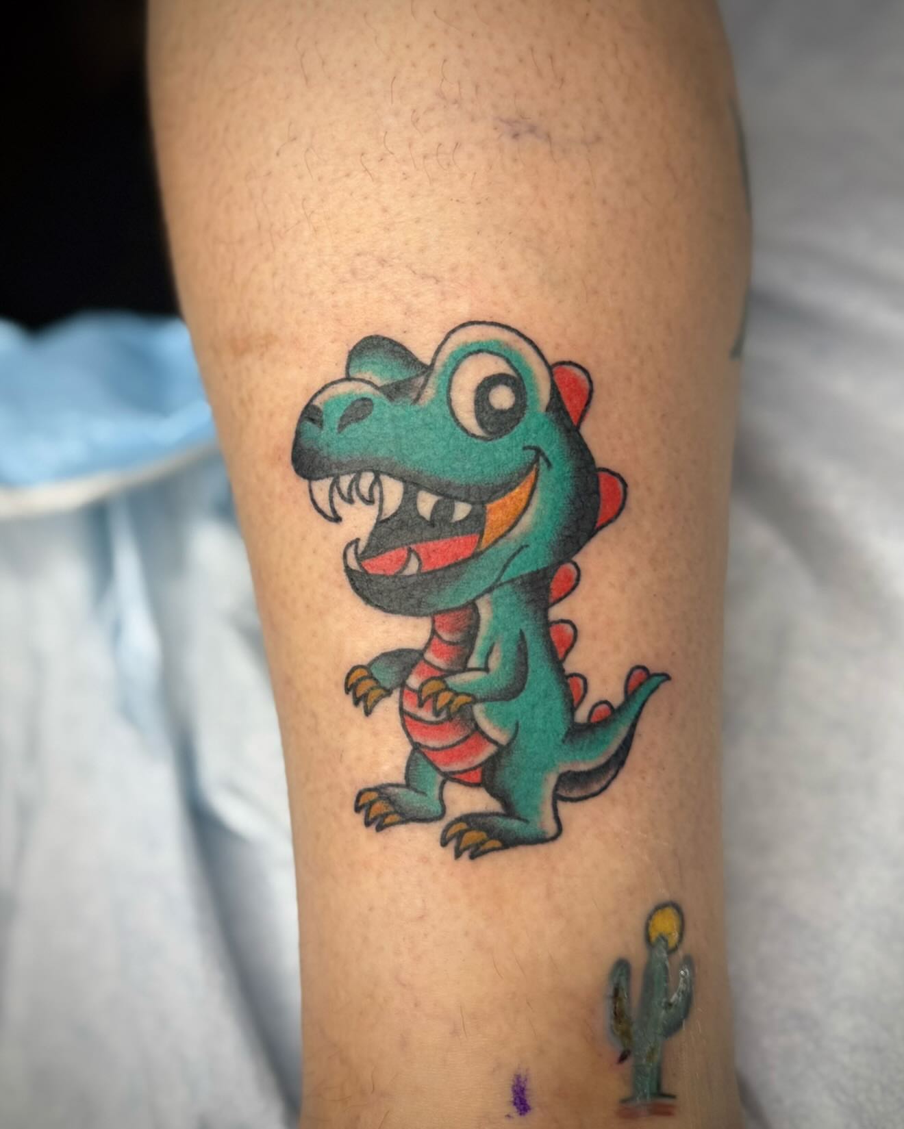 Dinosaur American traditional tattoo on the forearm by kalli berry