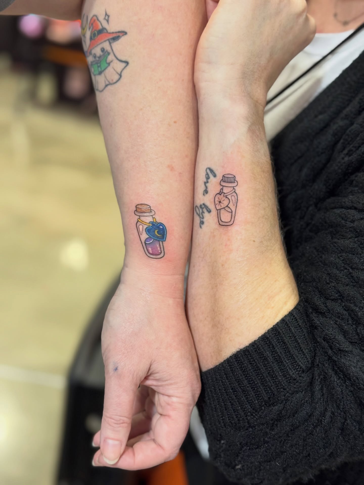 Bottle with flower dotwork tattoo on the forearm by North County Sd
