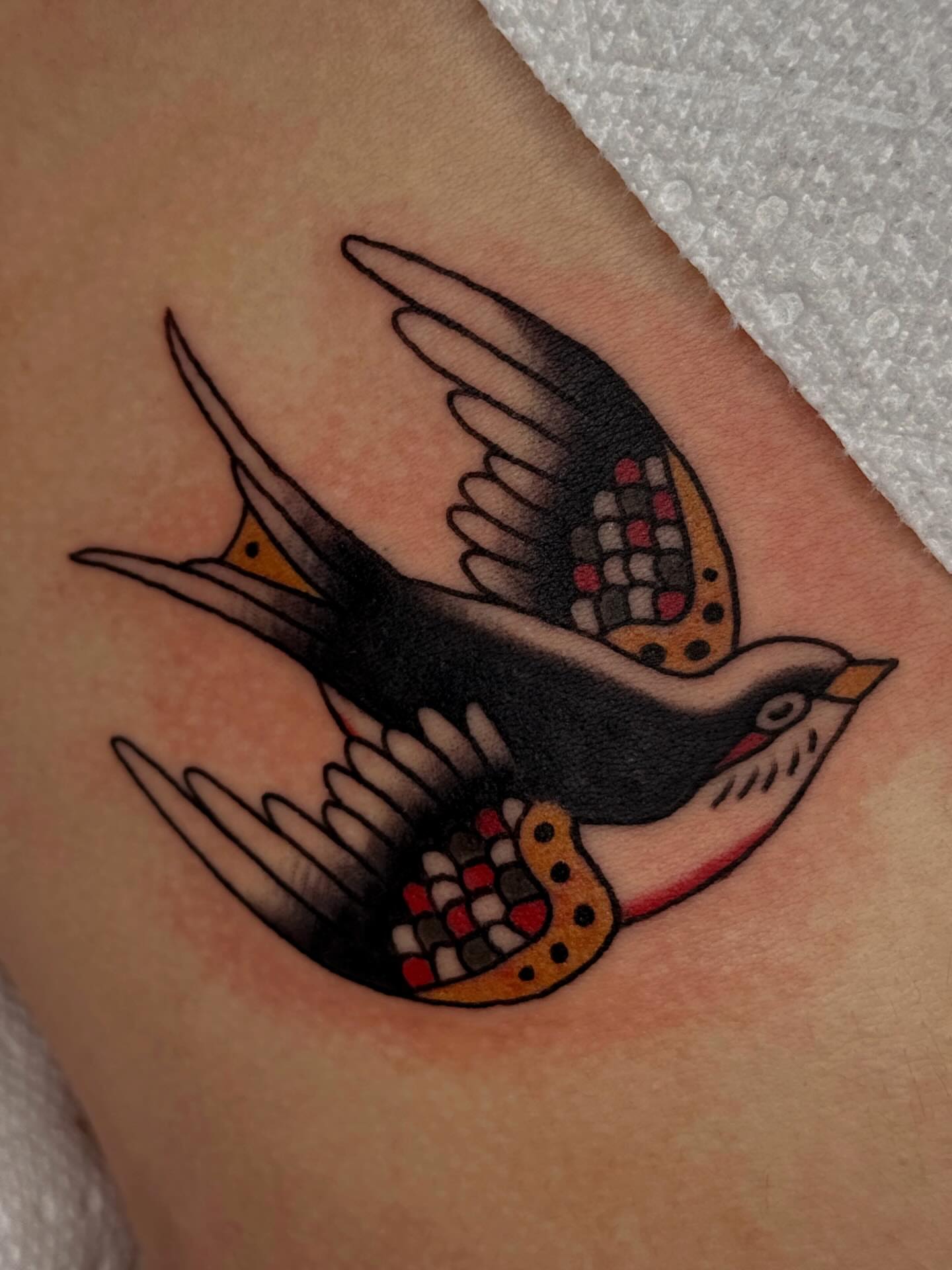Swallow American traditional tattoo on the forearm by Bridgette Carberry