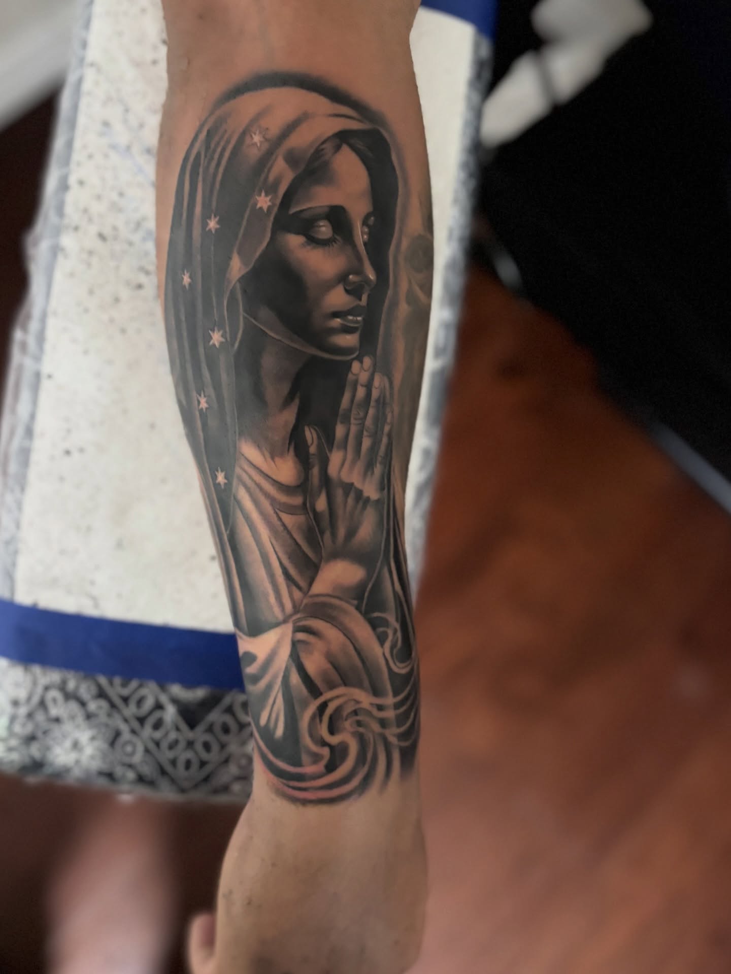 Religious figure praying realism tattoo on the forearm by @tattoosbyadrian