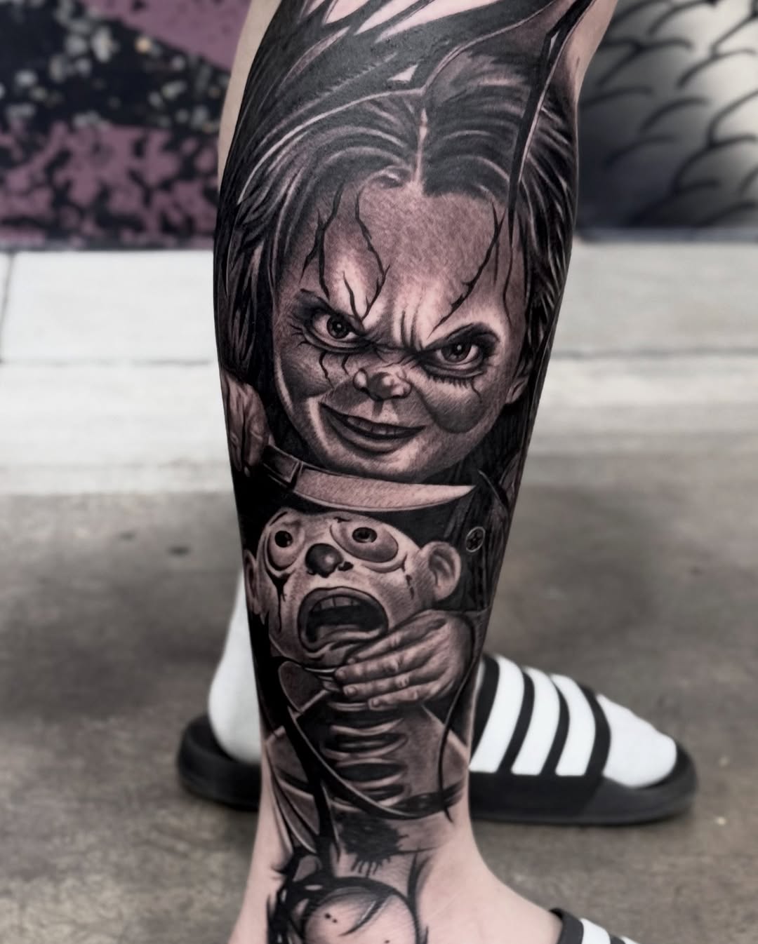 Chucky doll and victim realism tattoo on the calf by Chris galvis, Charlotte, North Carolina