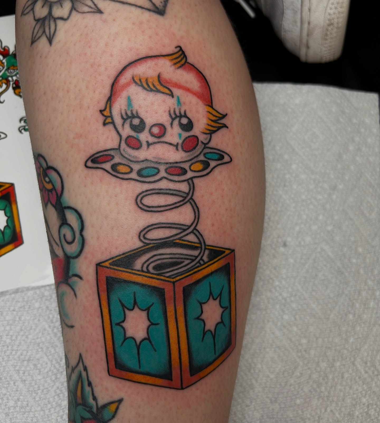 Joke box clown American traditional tattoo on the forearm by Dylan James