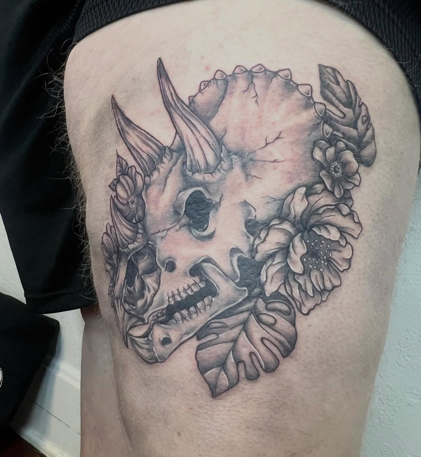 Skull with flowers realism tattoo on the thigh by Amber Rose