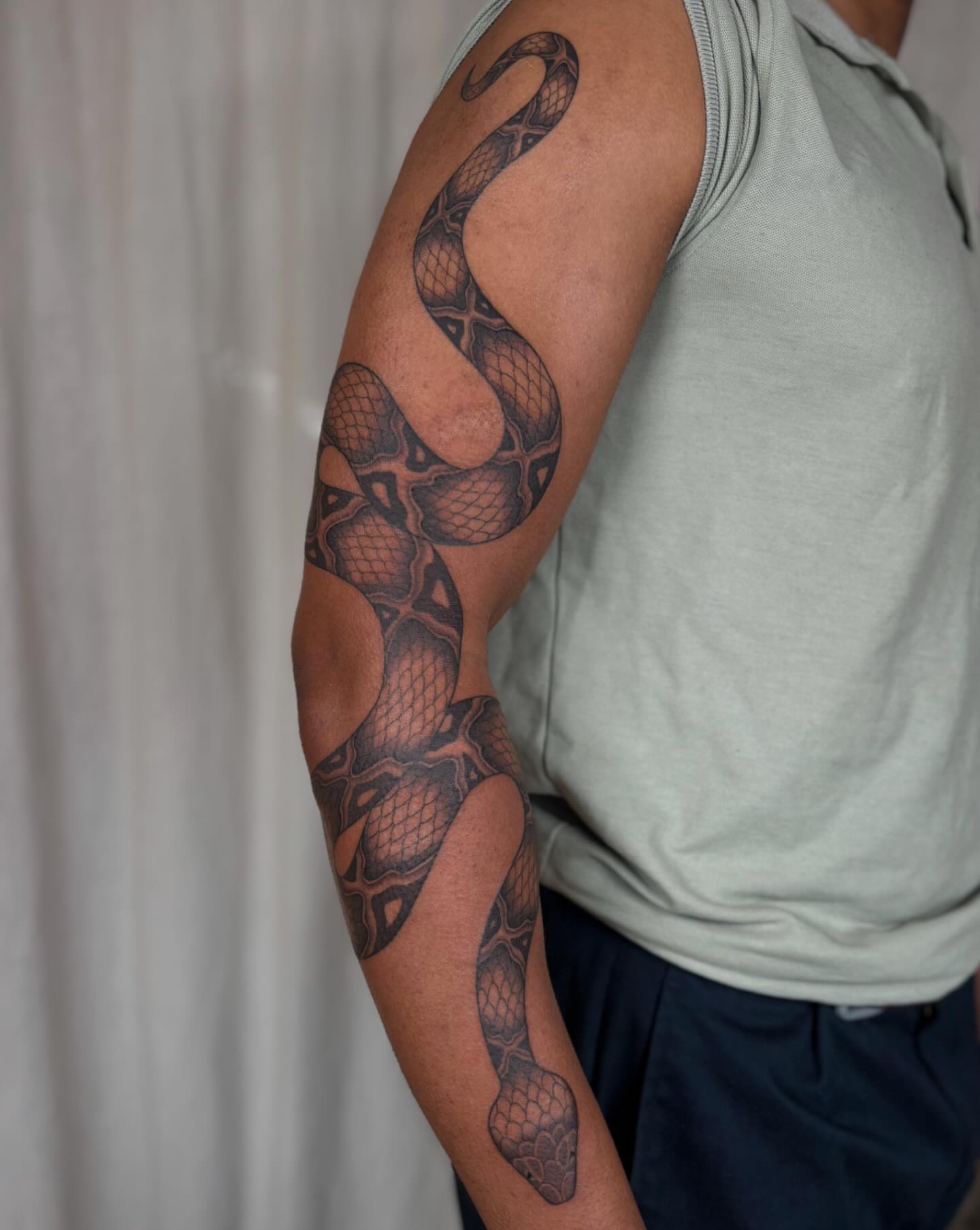 Snake black and grey tattoo on the forearm by Anna Sage