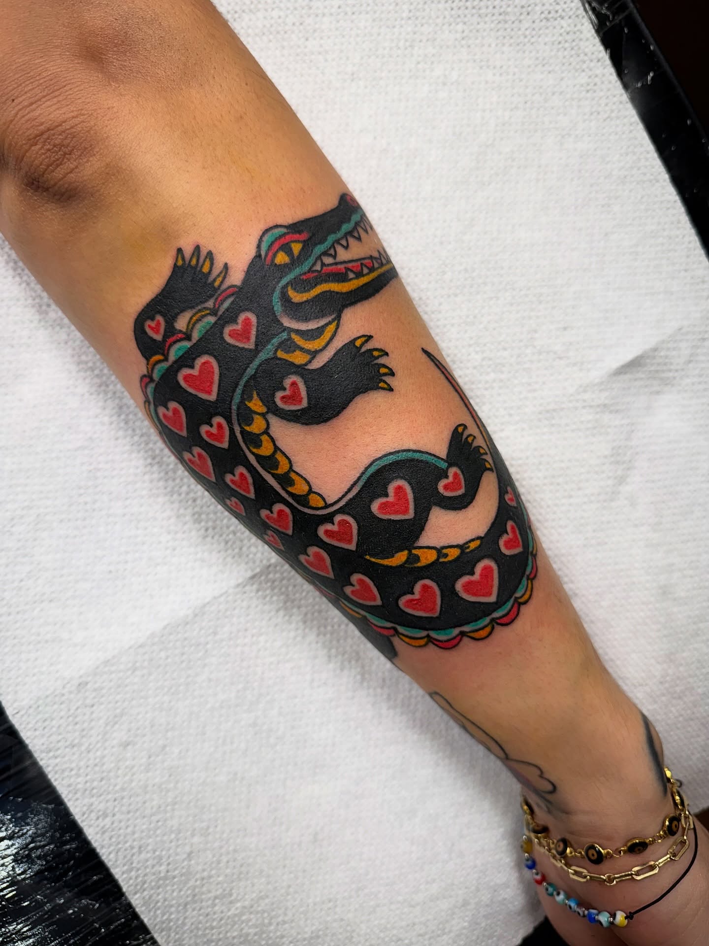 Alligator with hearts American traditional tattoo on the forearm by Shannon Pagliarini