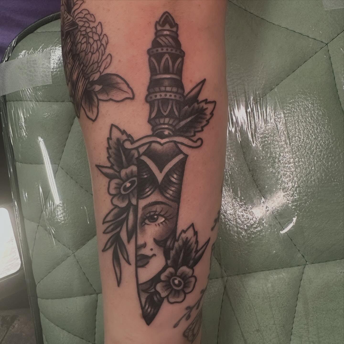 Woman's face with dagger American traditional tattoo on the forearm by Sammy Beresford