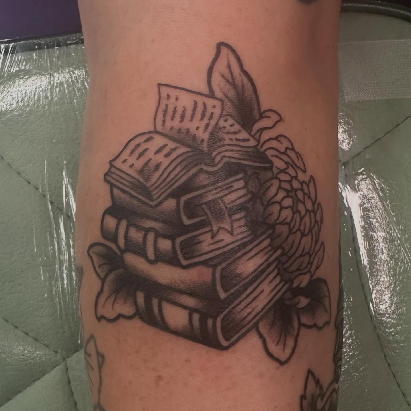 Stack of books black and grey tattoo on the forearm by Sammy Beresford
