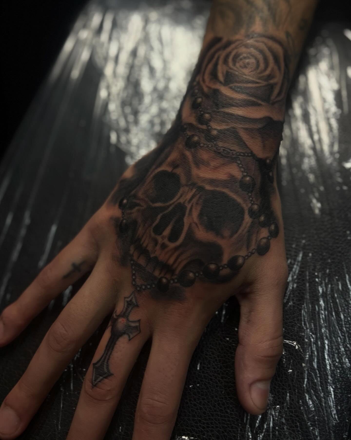 Skull and rosary realism tattoo on the hand by Lee
