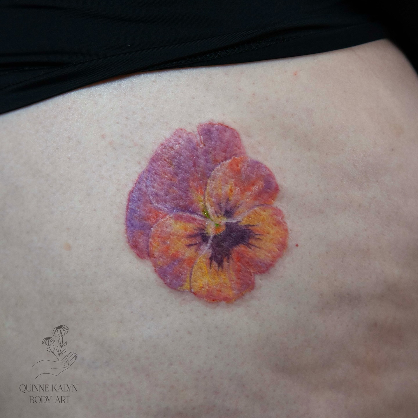Pansy watercolor tattoo on the thigh by Nashville Piercer & Tattoo Artist ✨ Quinne