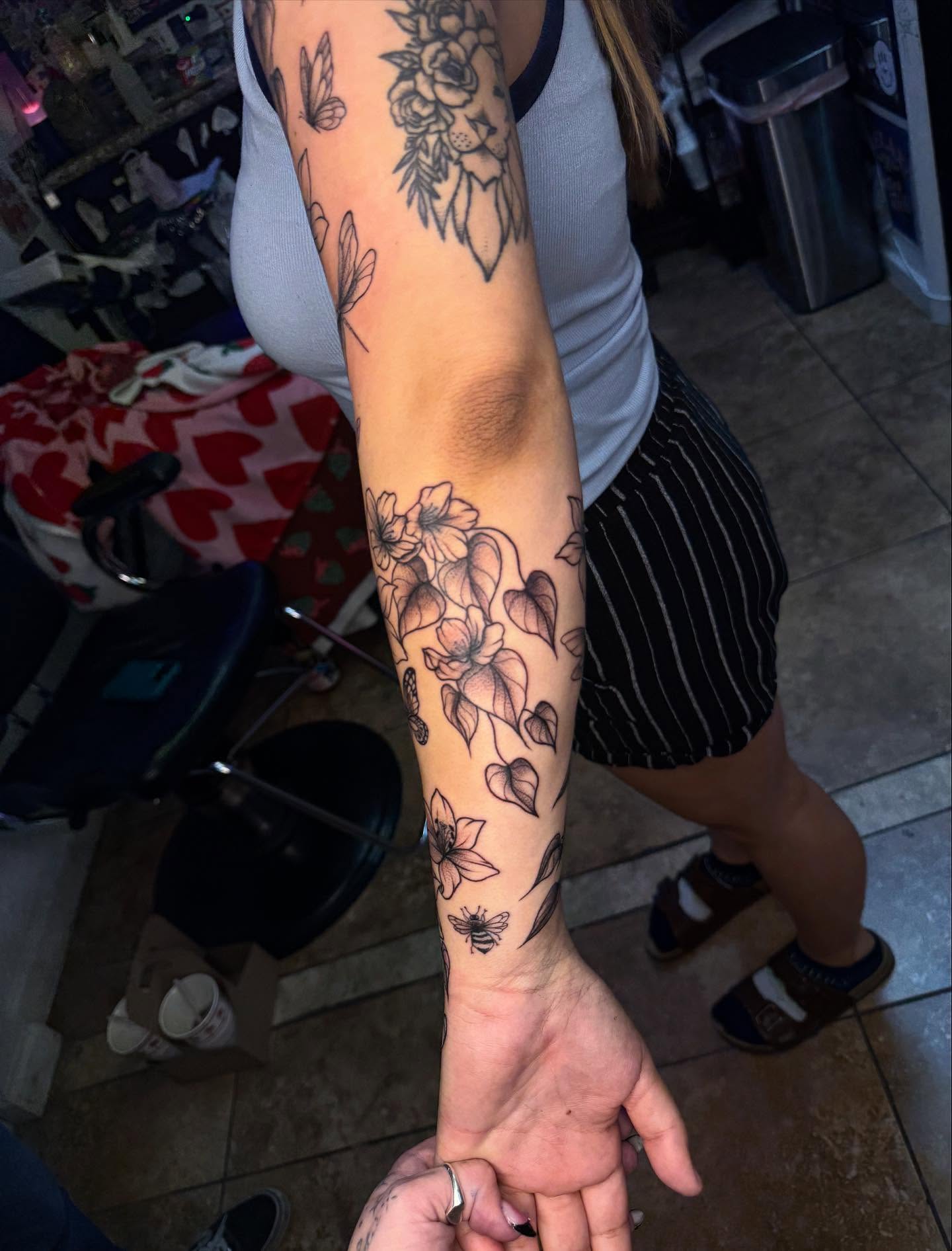 Floral bouquet black and grey tattoo on the forearm by McKenna Hughes