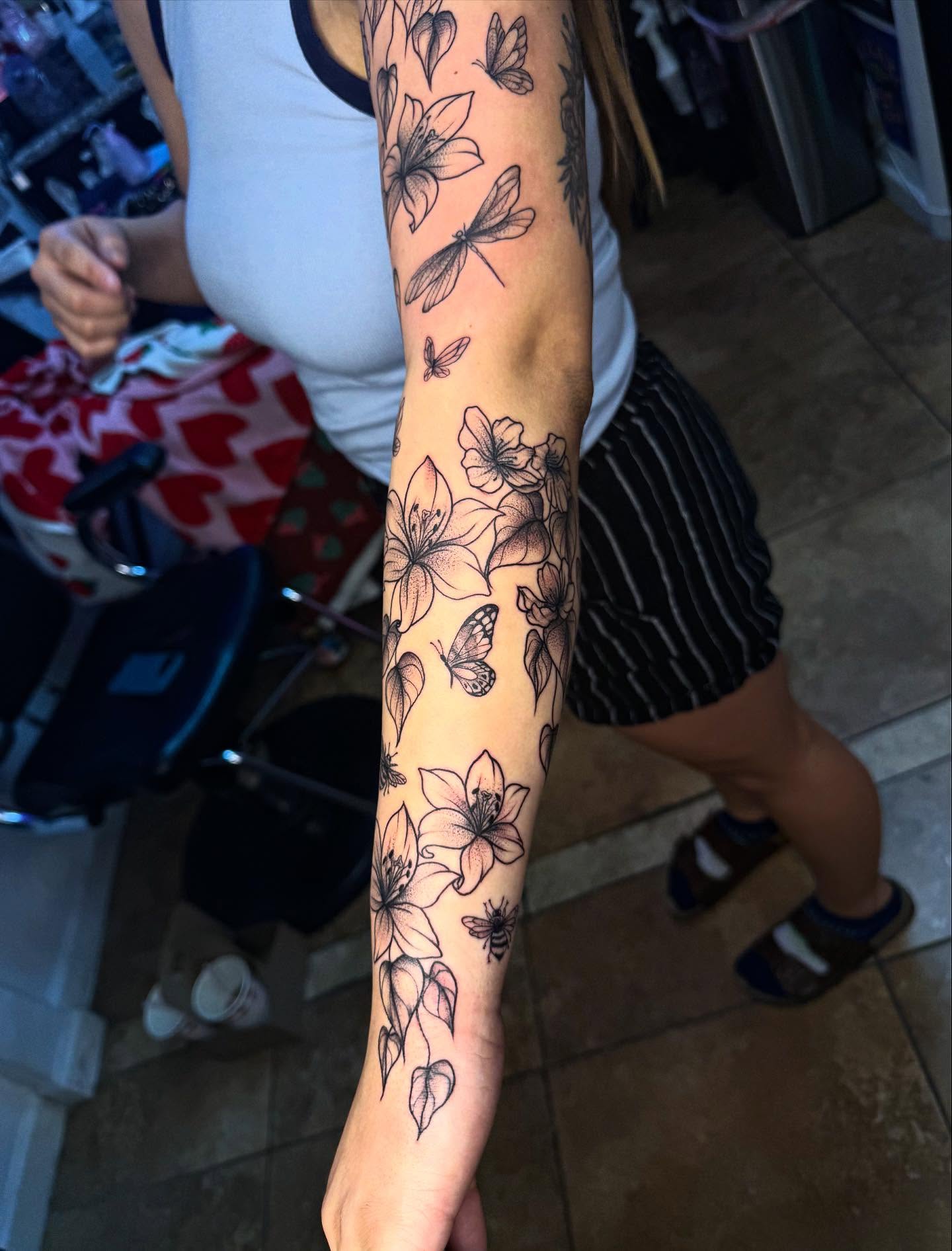 Flowers and butterflies black and grey tattoo on the forearm by McKenna Hughes