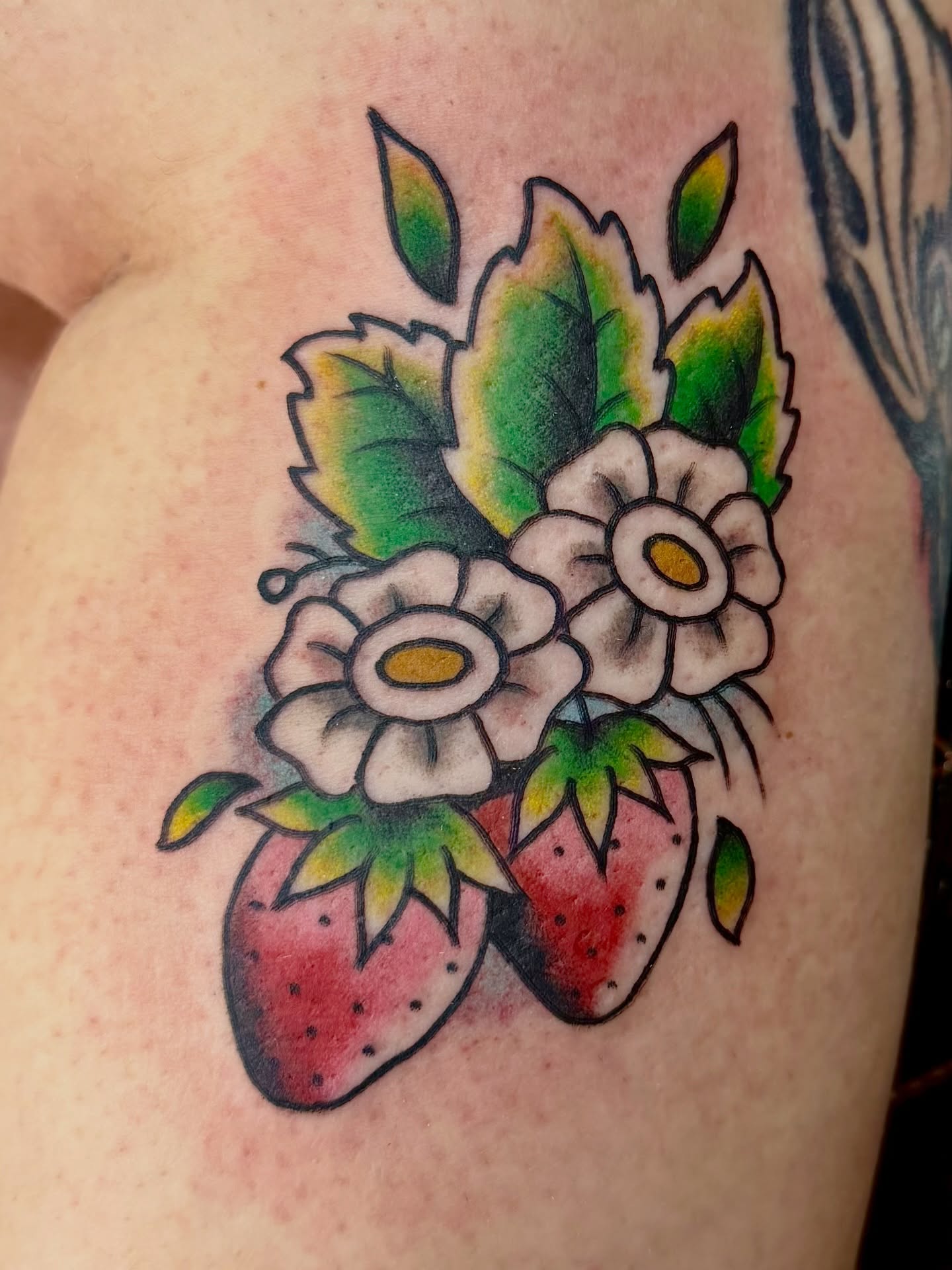 Strawberries and flowers American traditional tattoo on the shoulder by Josh Kronauer