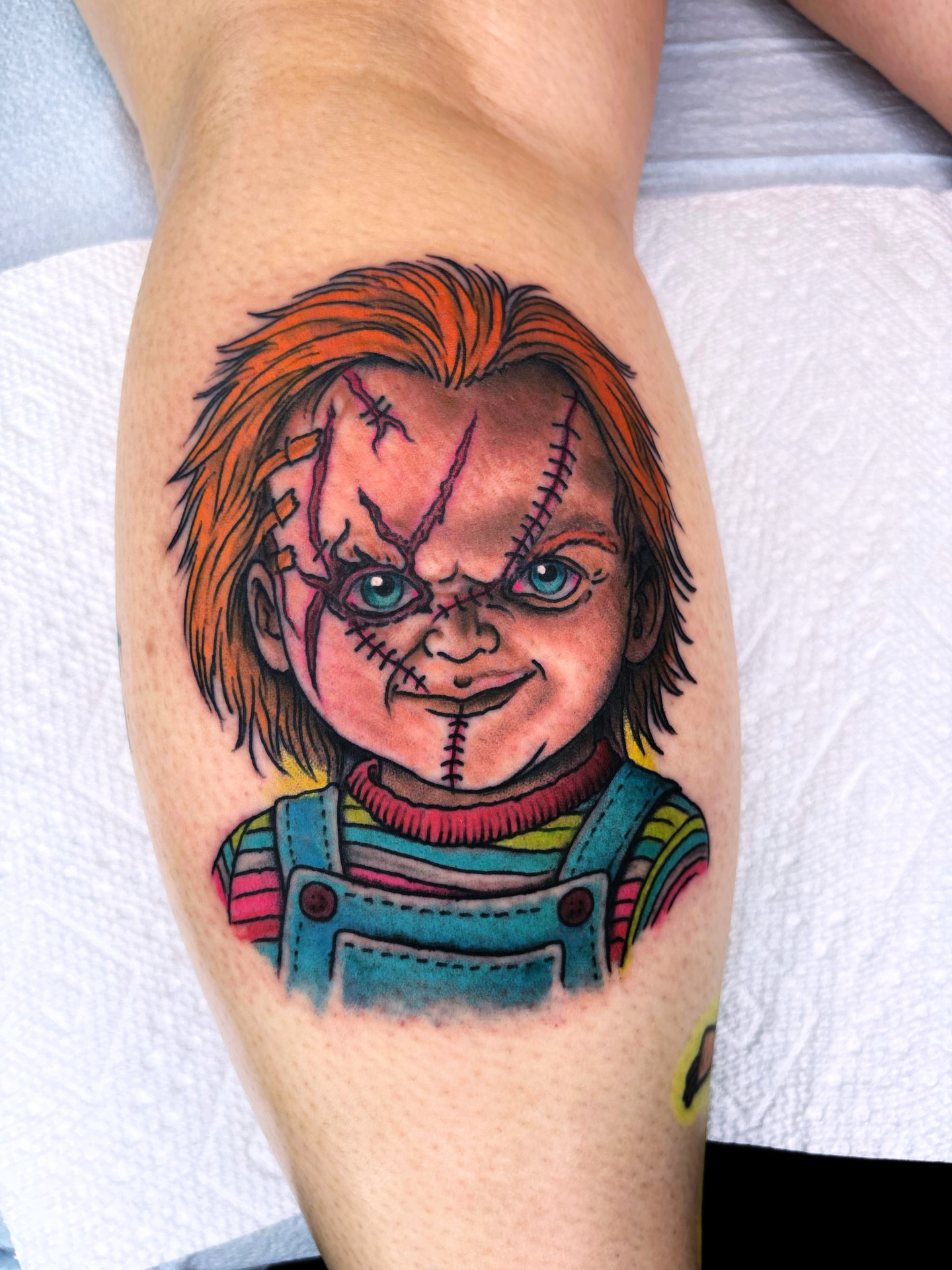 Chucky realism tattoo on the thigh by Randy Conner, Portland, Oregon
