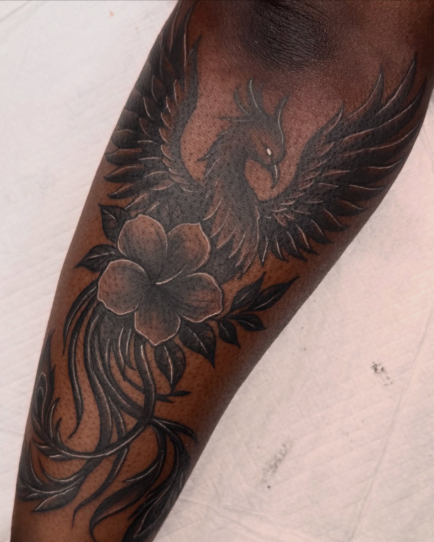 Phoenix and flower black and grey tattoo on the forearm by Elijah East