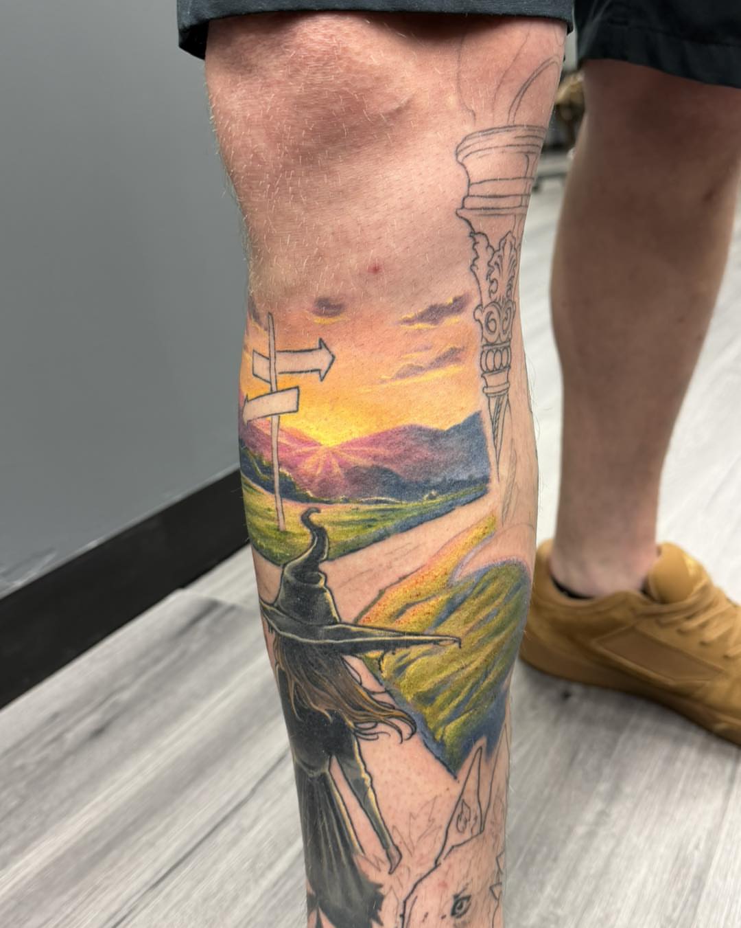 Landscape with witch realism tattoo on the calf by Harper Clark