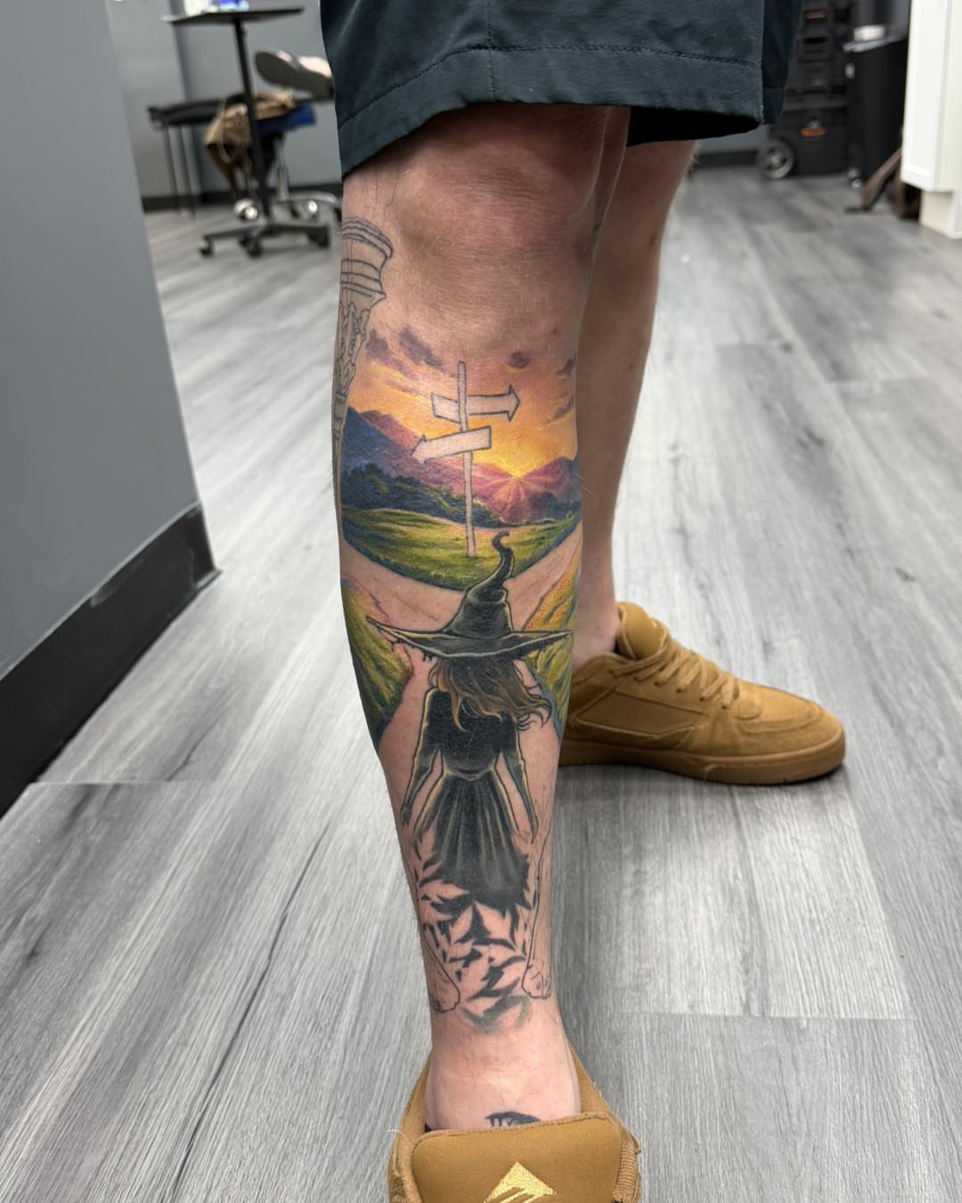 Wizard walking towards crossroads realism tattoo on the calf by Harper Clark