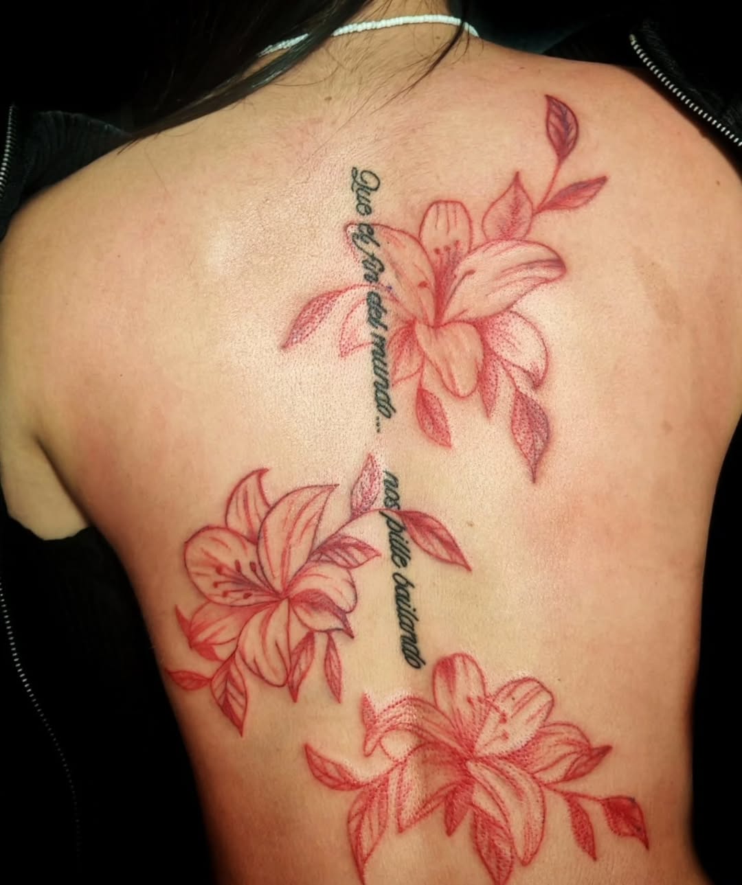 Lilies and script fine line tattoo on the back by Juanma Martin