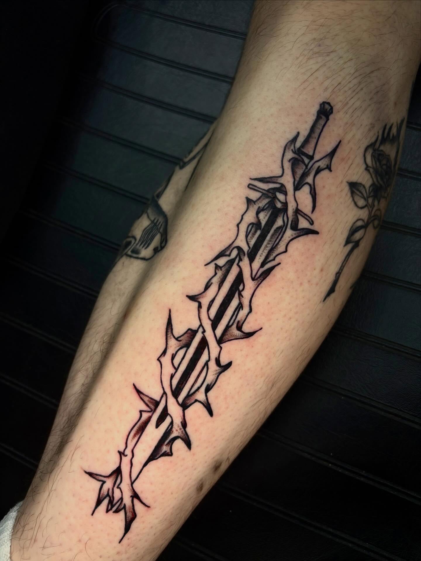 Sword and thorns black and grey tattoo on the forearm by Jenna Clayton
