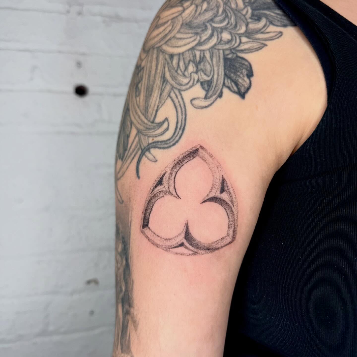 Three-leaf clover black and grey tattoo on the upper arm by Kenny ๐ด