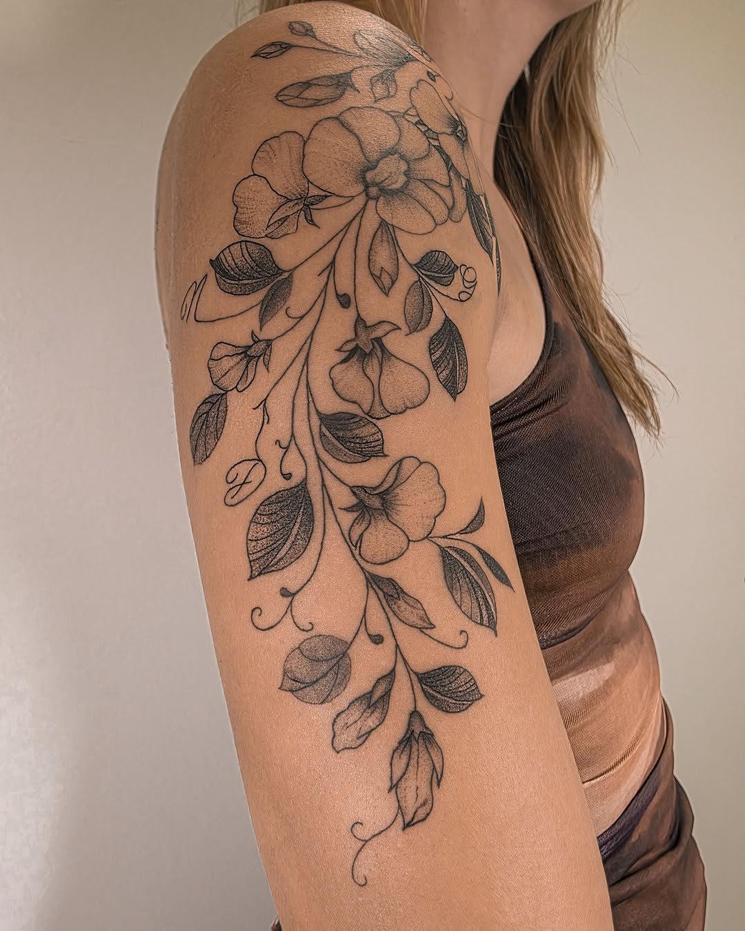 Floral vine fine line tattoo on the upper arm by Richmond tattoo shop, Richmond, Texas