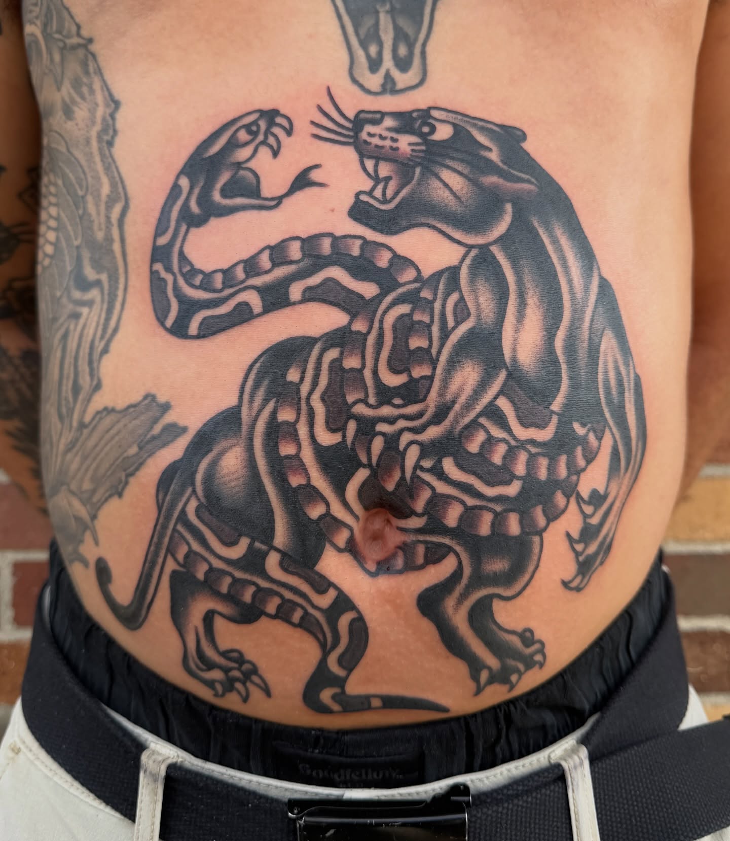 Panther and snake black and grey tattoo on the ribs by Nick Judkins Tattoo