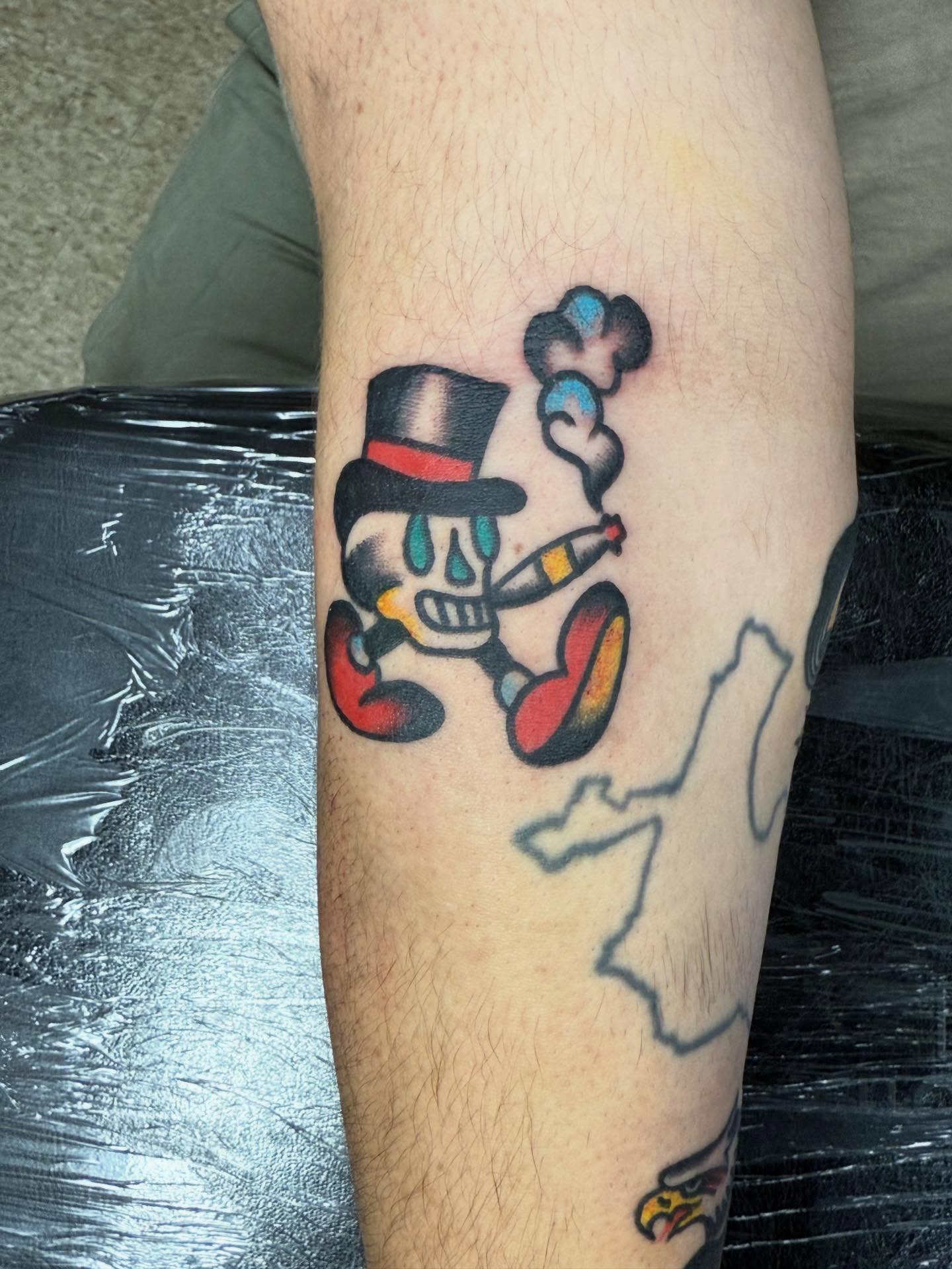 Skull smoking American traditional tattoo on the forearm by Jesse Coldiron