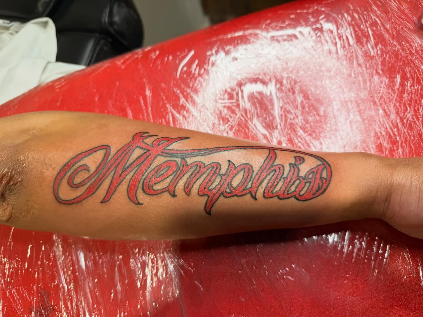 Memphis lettering script tattoo on the forearm by Jones Eric