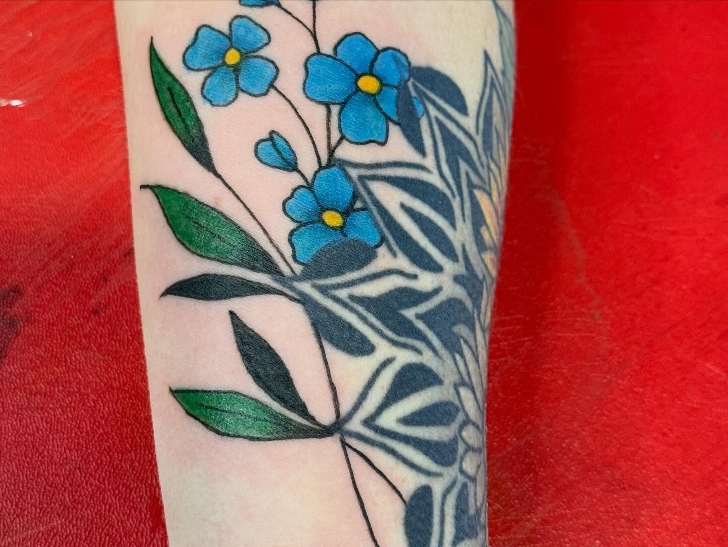 Blue flowers dotwork tattoo on the forearm by Jones Eric