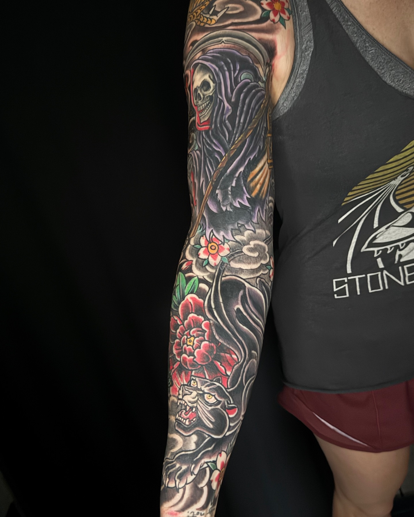 Reaper and tiger American traditional tattoo on the upper arm by Chris Cockrill